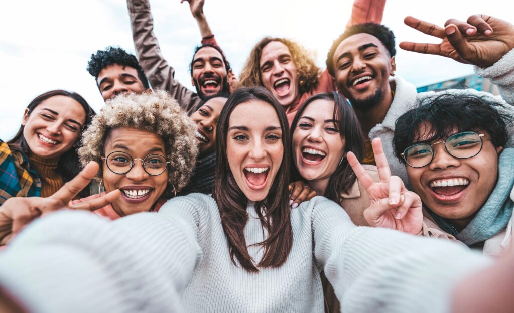 Multicultural young people smiling together at camera outside